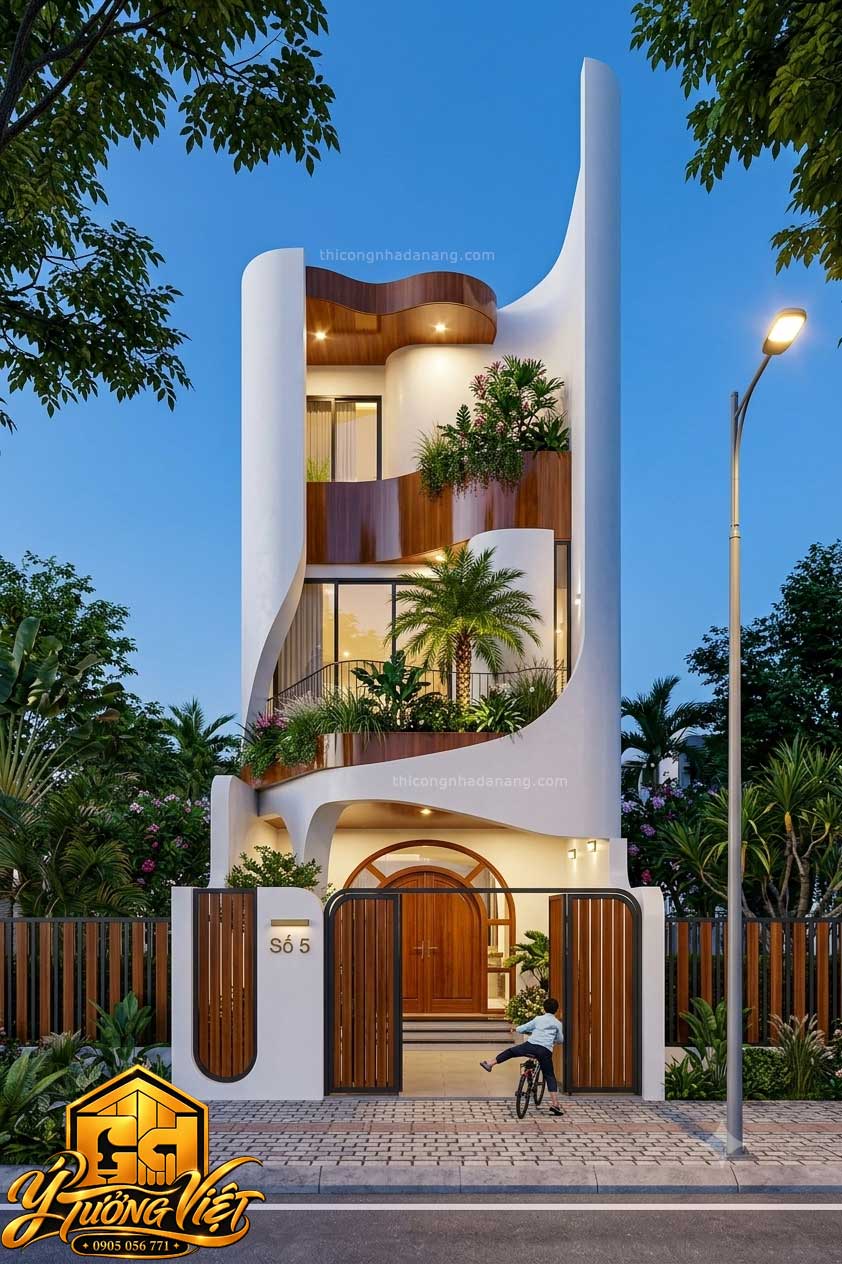 Mẫu nhà phố 3 tầng mặt tiền 6m với tường trắng uốn cong, mảng ốp màu nâu gỗ và ban công cây xanh
